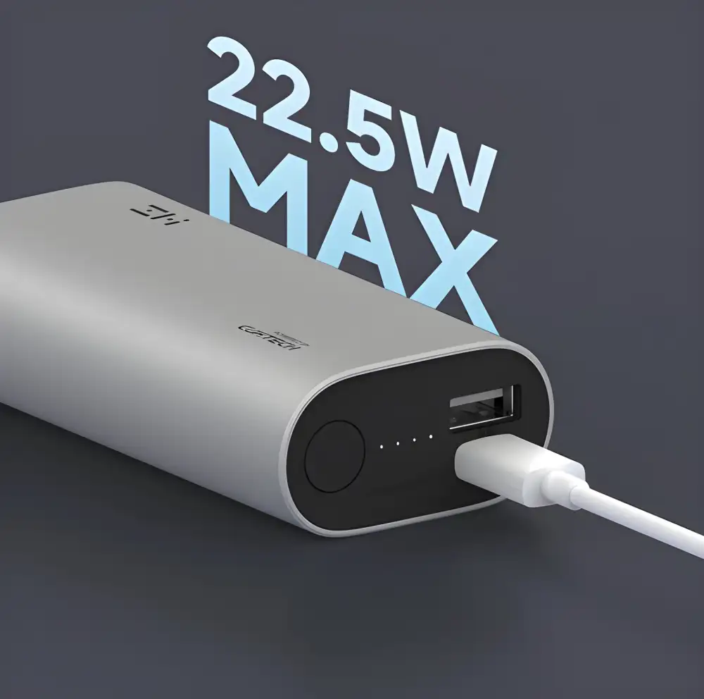 A side-by-side view of the Cuktech ZMI QB818 and a smartphone, emphasizing its miniature footprint while charging at 30W