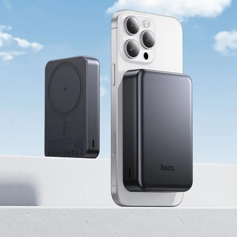 A lifestyle image showing the power bank magnetically attached to an iPhone,
