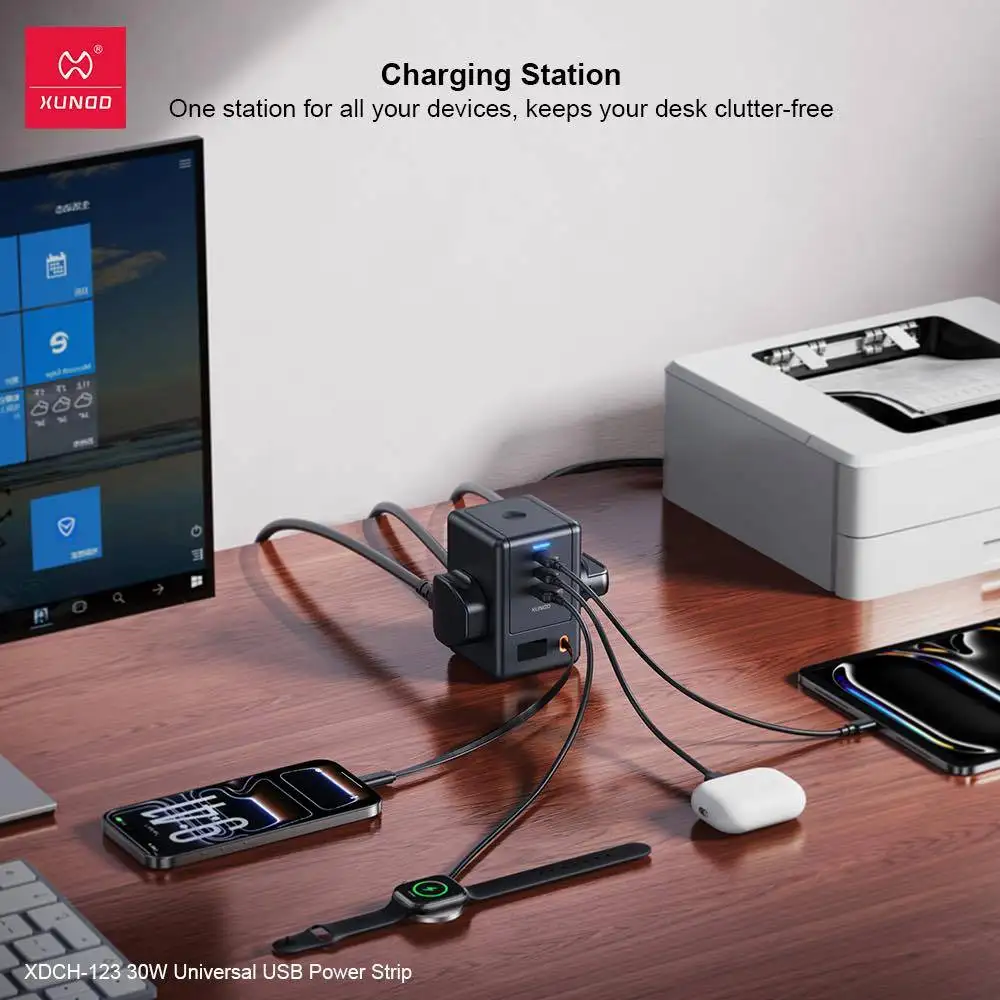 A lifestyle photo of the power strip placed beside a laptop on a home desk,